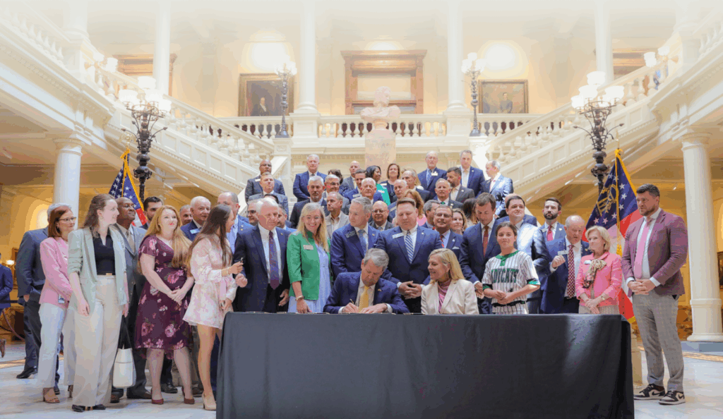 Governor Kemp signing a bill after Frontline's advocacy to raise the standard with legislative victories in Georgia.